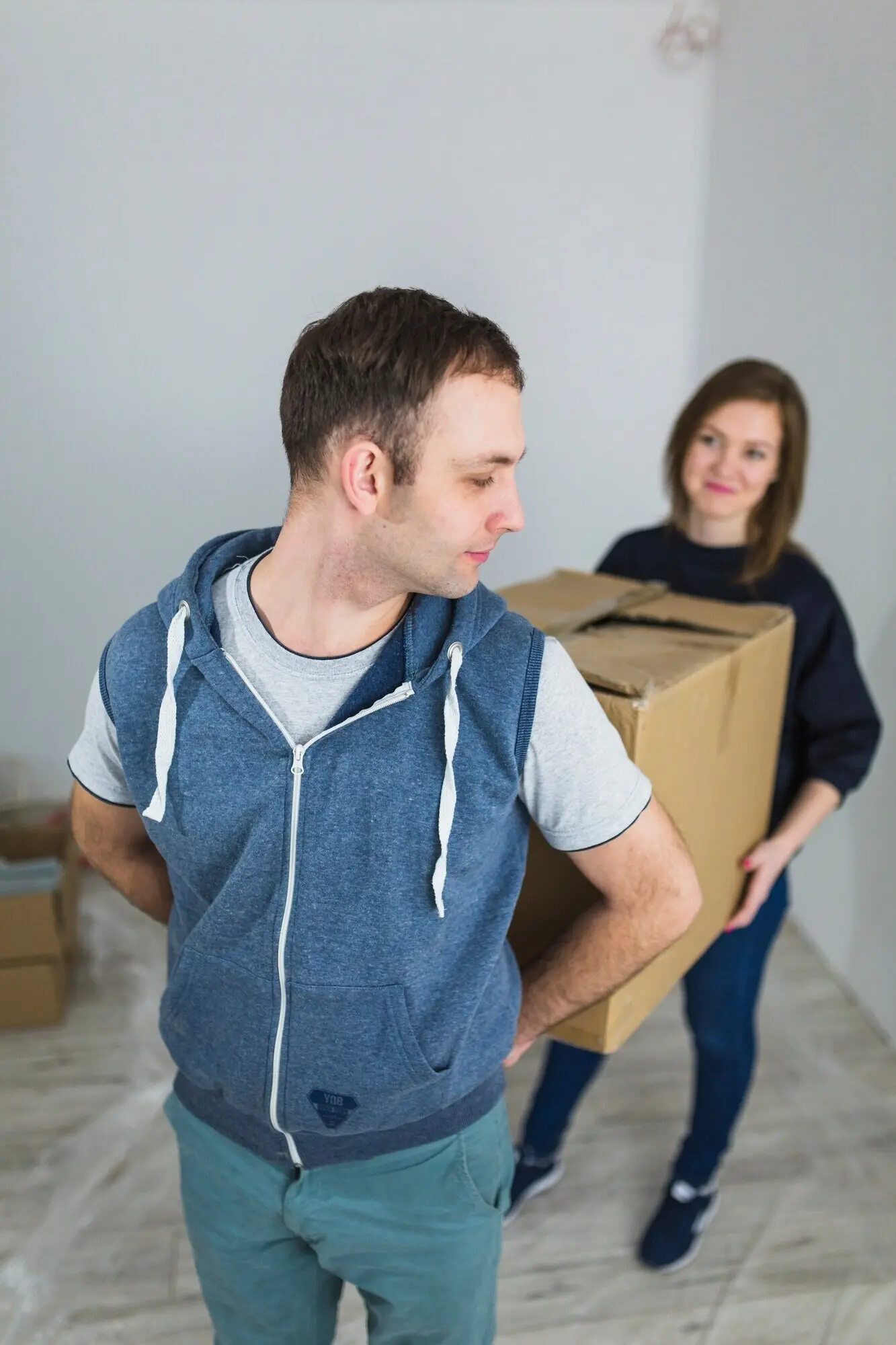 Ein Paar trägt eine schwere Kiste.